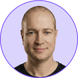 A headshot of David Moradi. A caucasian male with no hair wearing a dark gray t-shirt.