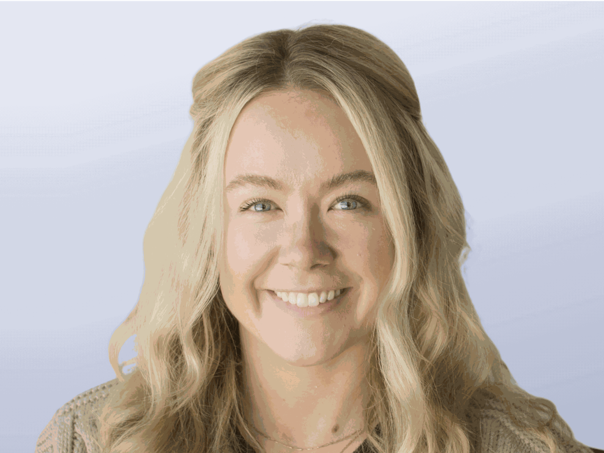 A headshot of Brittani Morelli. A caucasian woman with long blonde wavy hair, wearing a ran sweater.