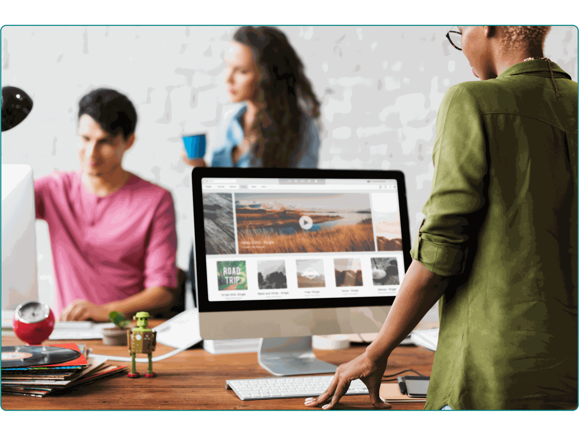 A woman standing and working at a desktop monitor for a digital design agency