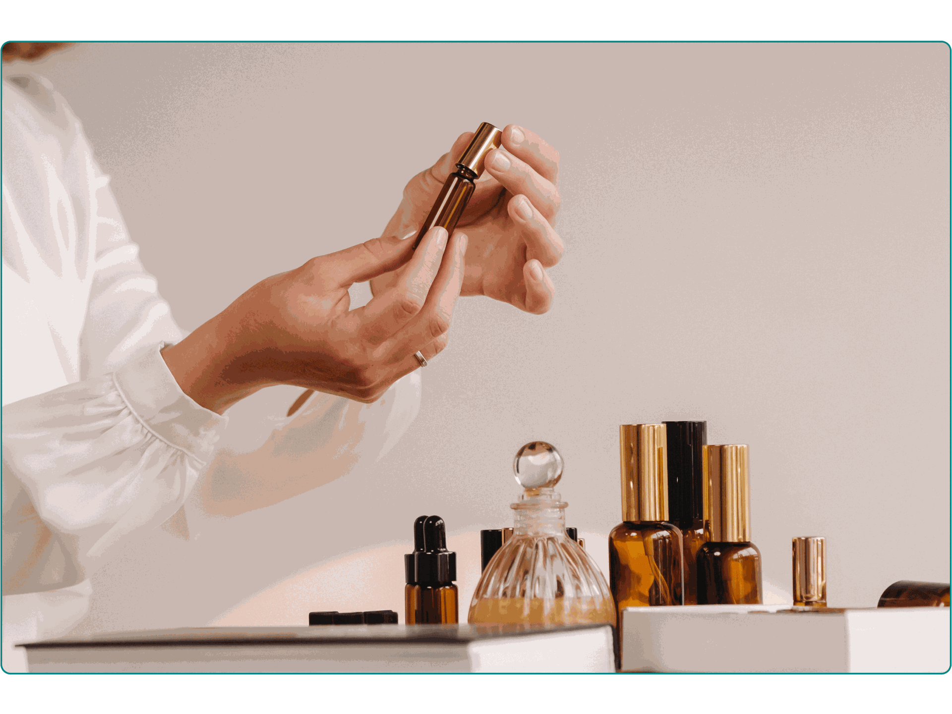 A close-up shot of a woman putting on perfume with other aromatherapy bottles around her.