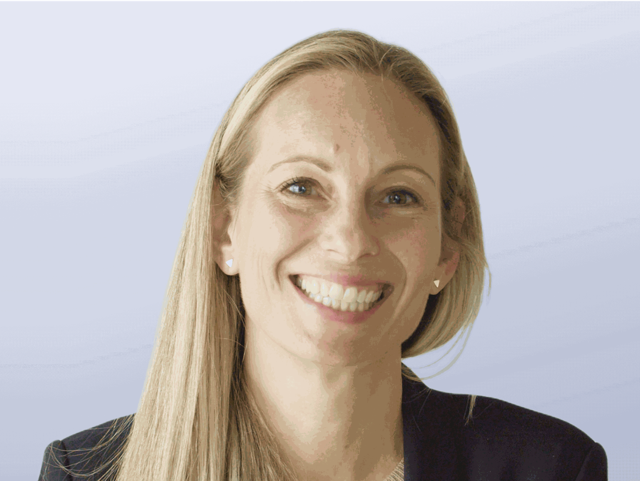 A headshot of Kelly Georgevich. A caucasian woman with long blonde hair wearing a black blazer.