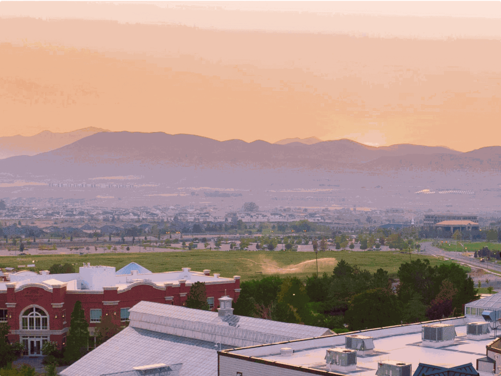 Lehi, Utah skyline at sunset with a mountain range in the distance.
