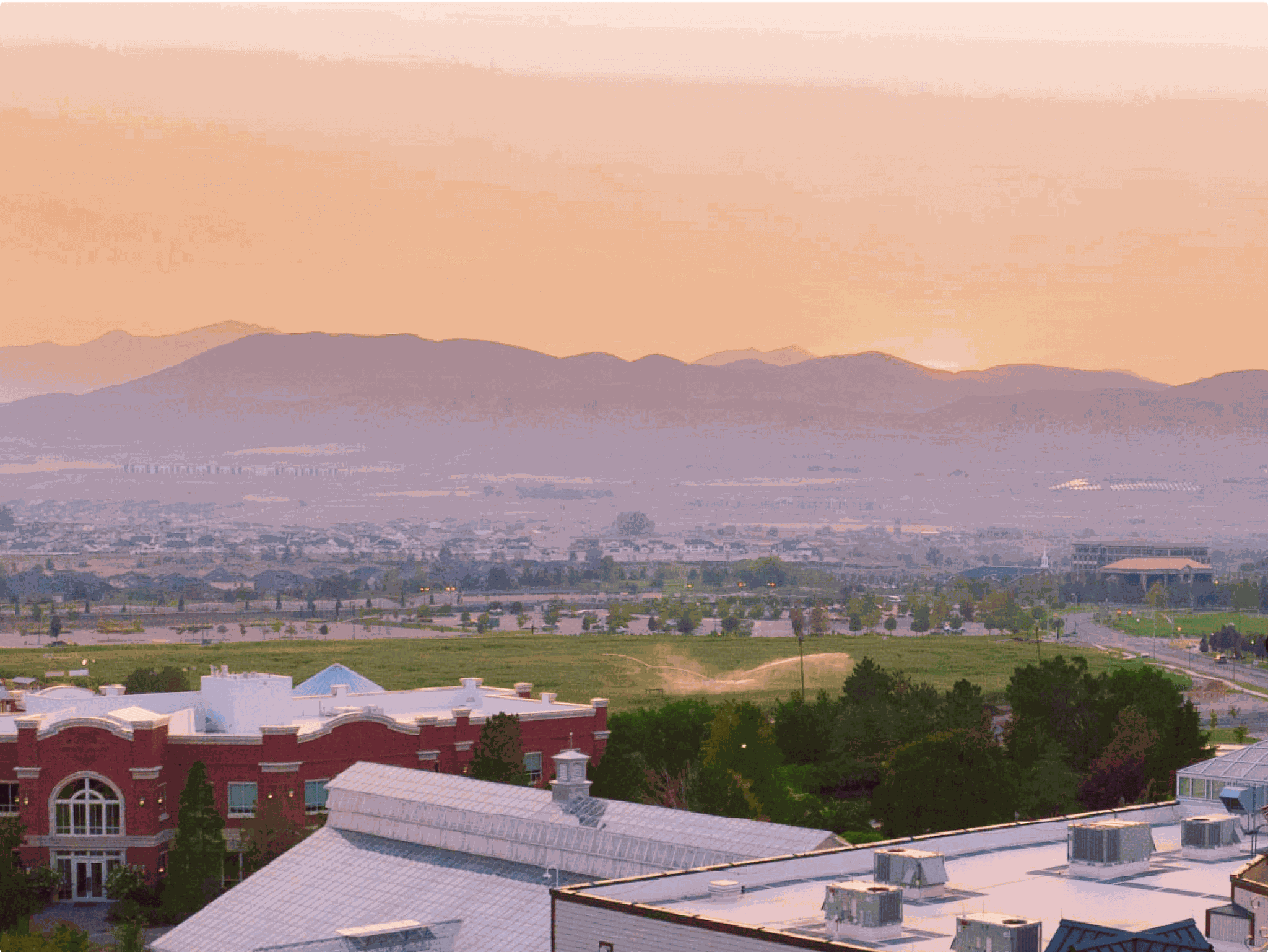 Lehi, Utah skyline at sunset with a mountain range in the distance.