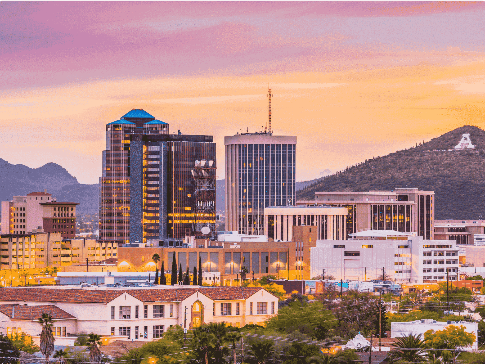 Tucson, Arizona skyline at sunset with A mountain in the distance.