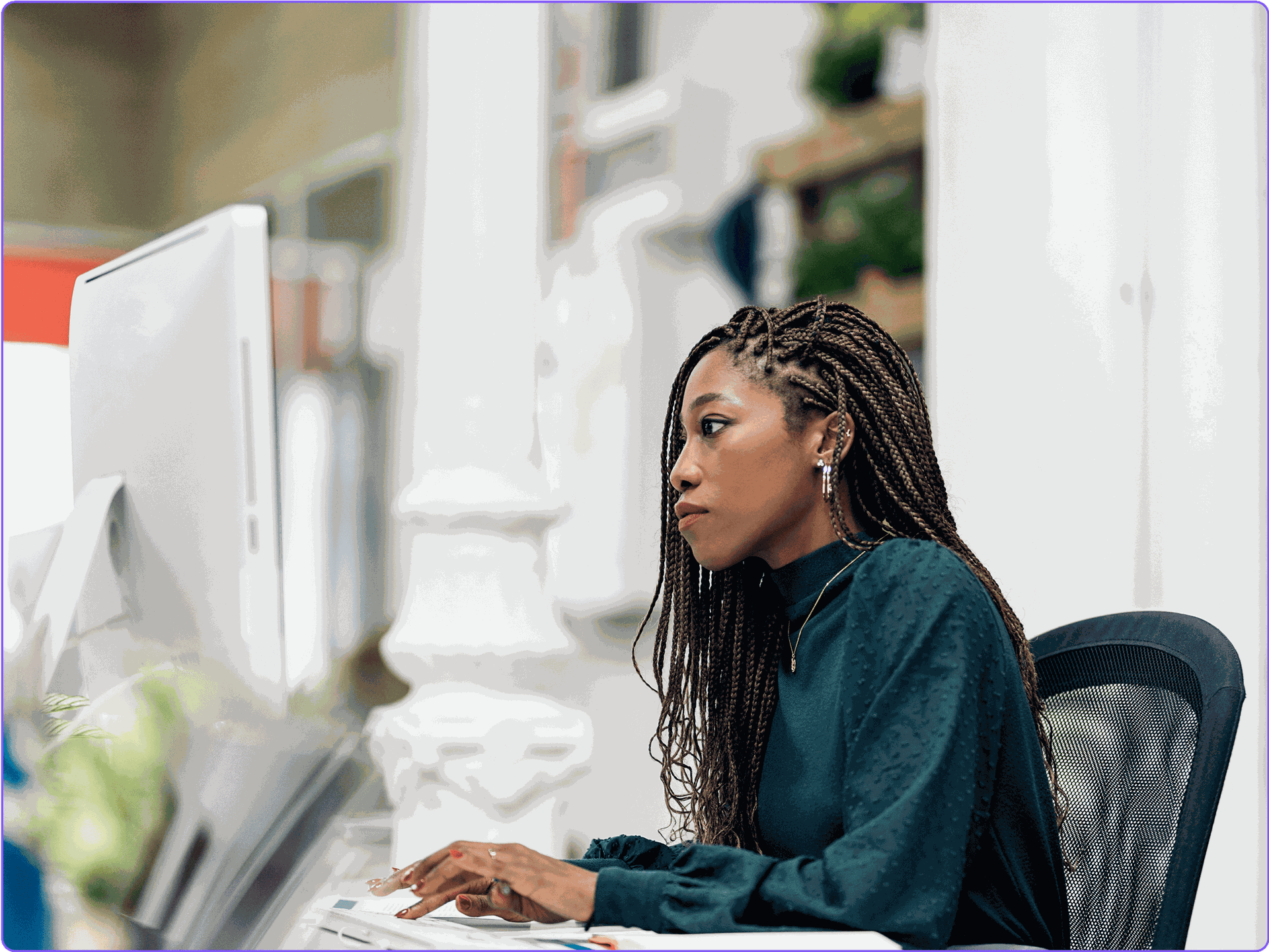 A female marketer reviewing campaign metrics on a desktop monitor.