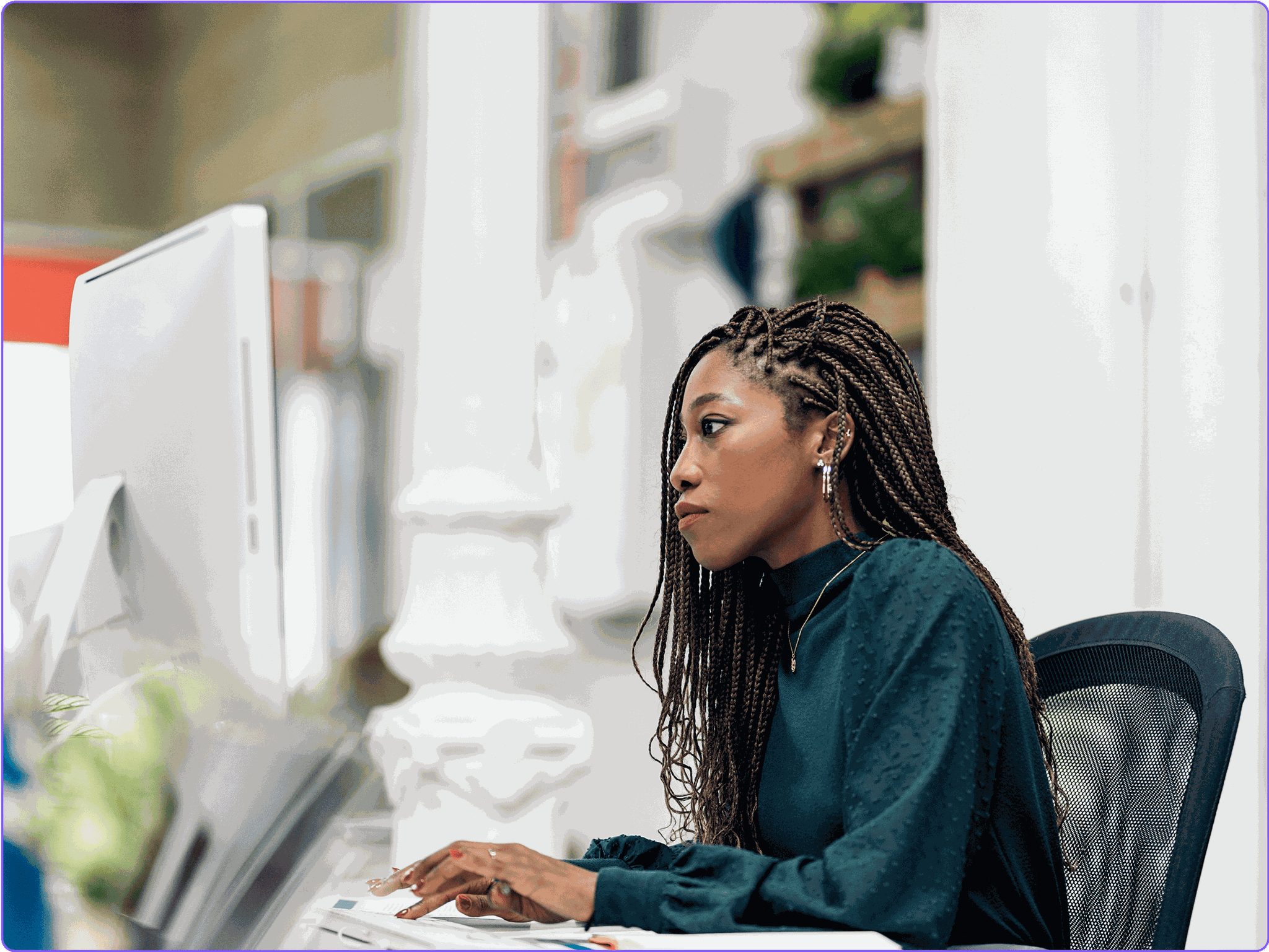 A female marketer reviewing campaign metrics on a desktop monitor.