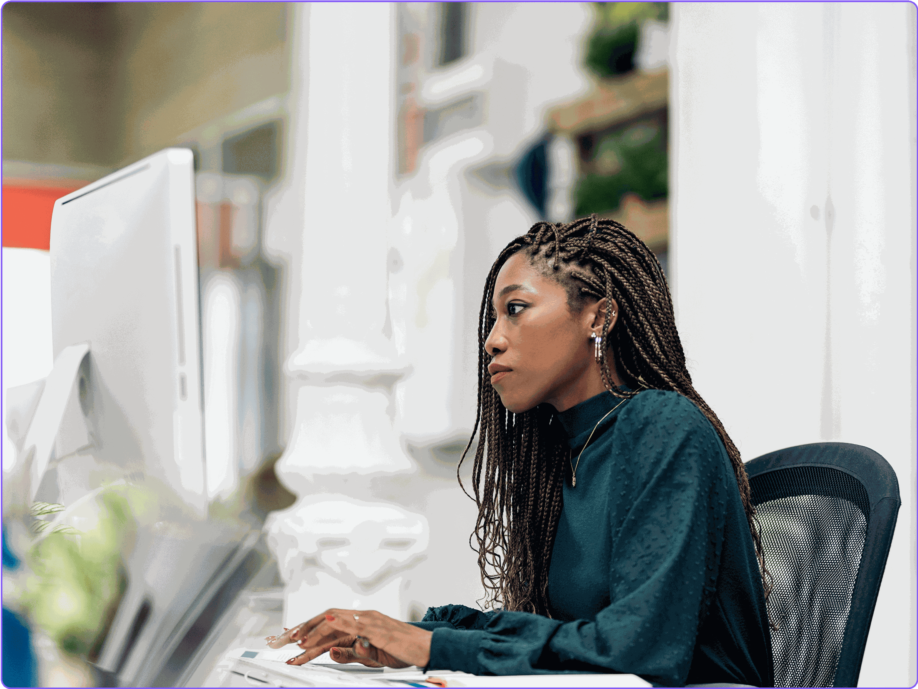 A female marketer reviewing campaign metrics on a desktop monitor.