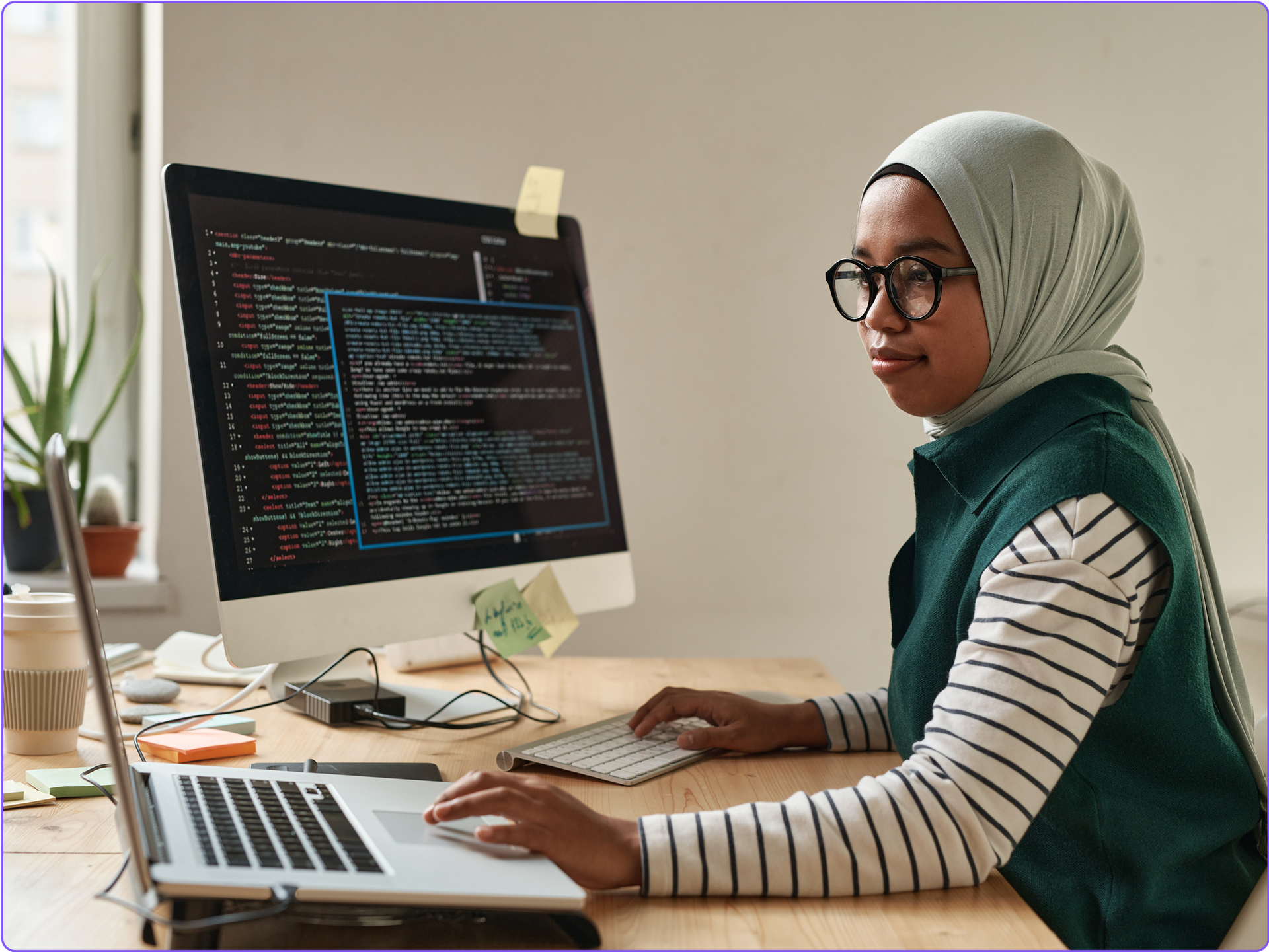 A software developer with a code editor on her desktop monitor.