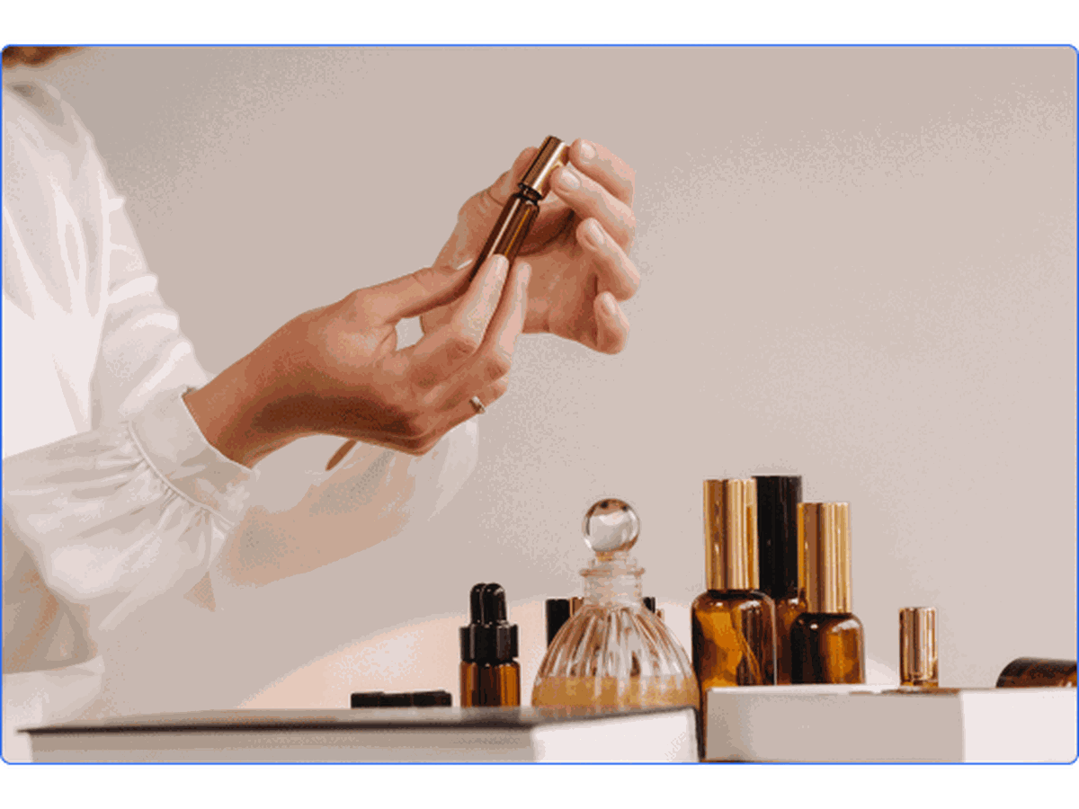 A woman putting on perfume with other aromatherapy bottles around her.