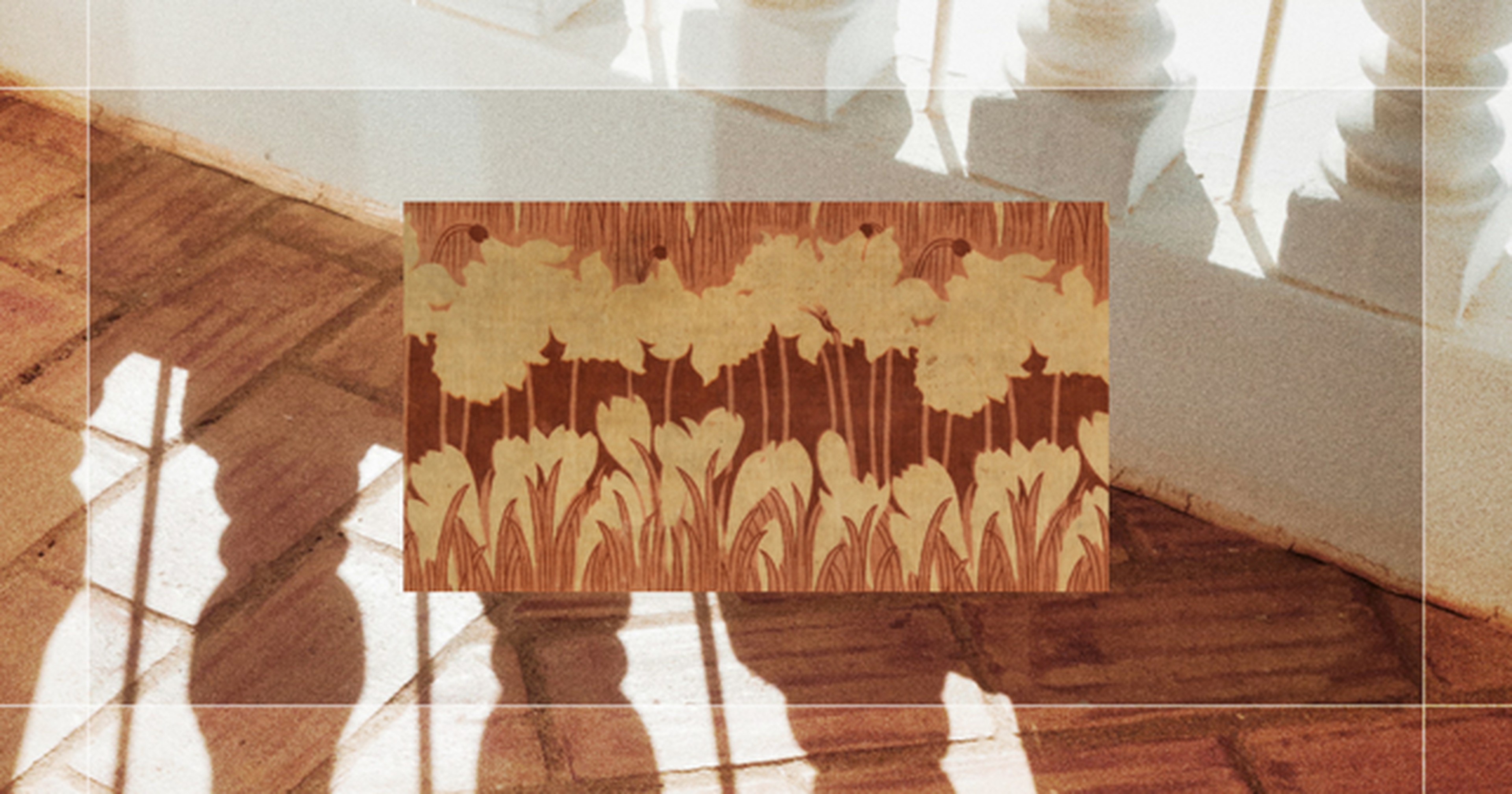 A decorative panel featuring a floral pattern in earthy tones, set against a sunlit walkway with shadows from a railing.