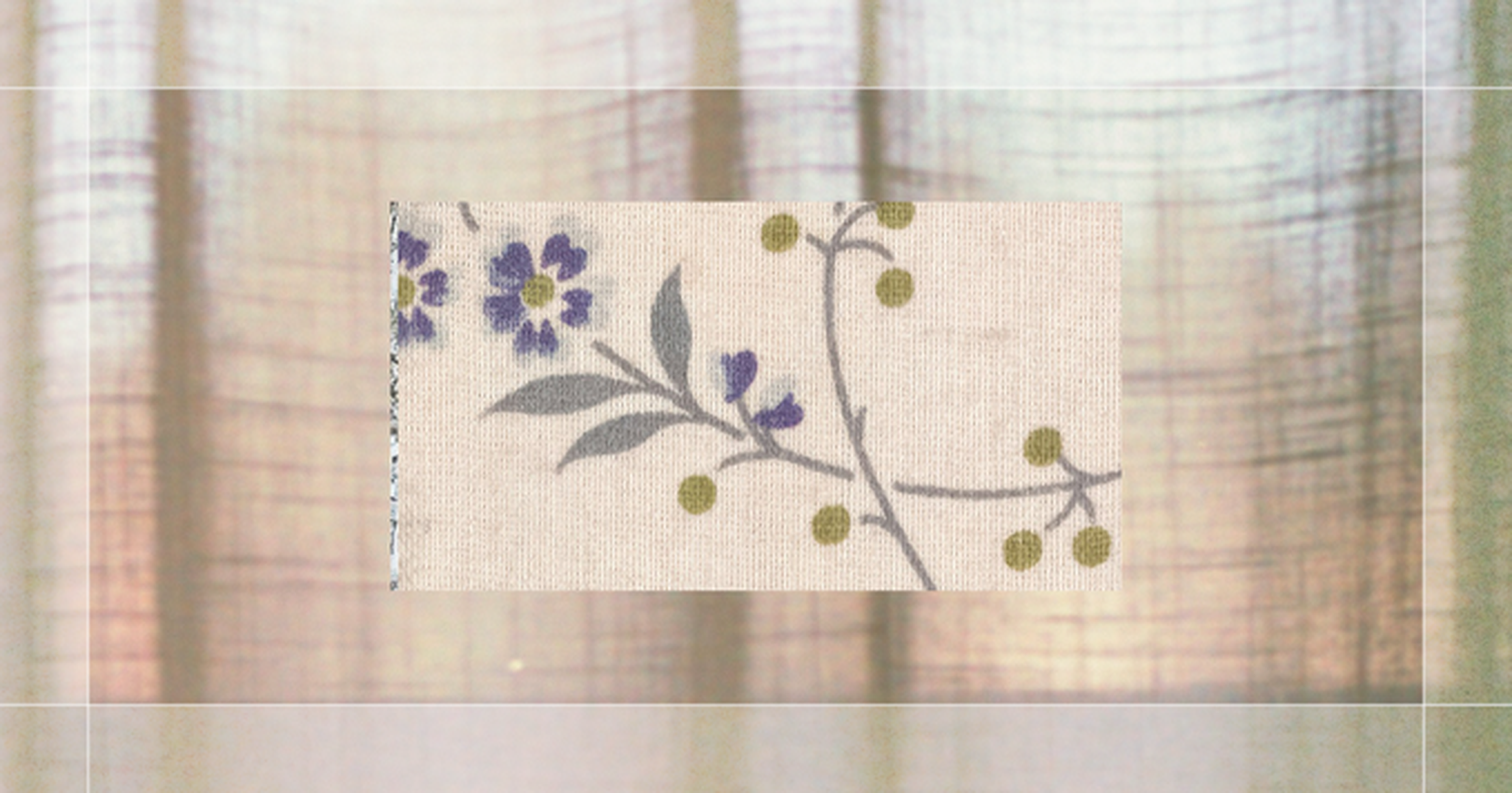 Fabric sample with floral design featuring purple flowers and green circles on a beige background, overlaid on blurred striped curtains.